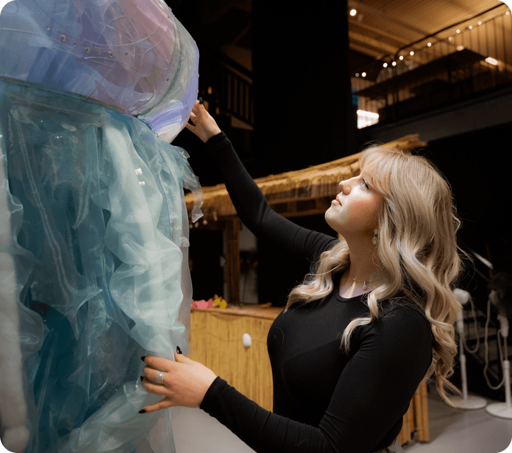 Emelie arbetar med många olika produktioner, här tillsammans med rekvisita från produktionen av Masked Singer.